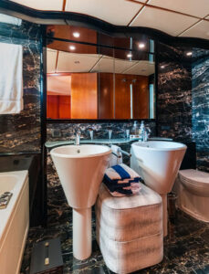 Luxurious Yacht Bathroom with Marble Design Modern yacht bathroom with a luxurious marble finish, twin sinks, and a bathtub.